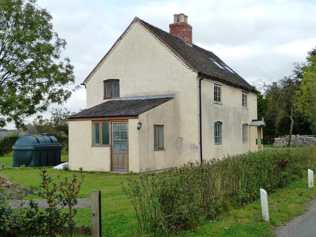 Two-storey house with a green non-metallic heating oil tank in the side yard